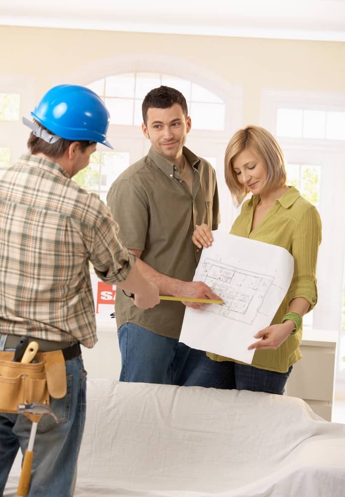 contractor discussing construction plans with couple