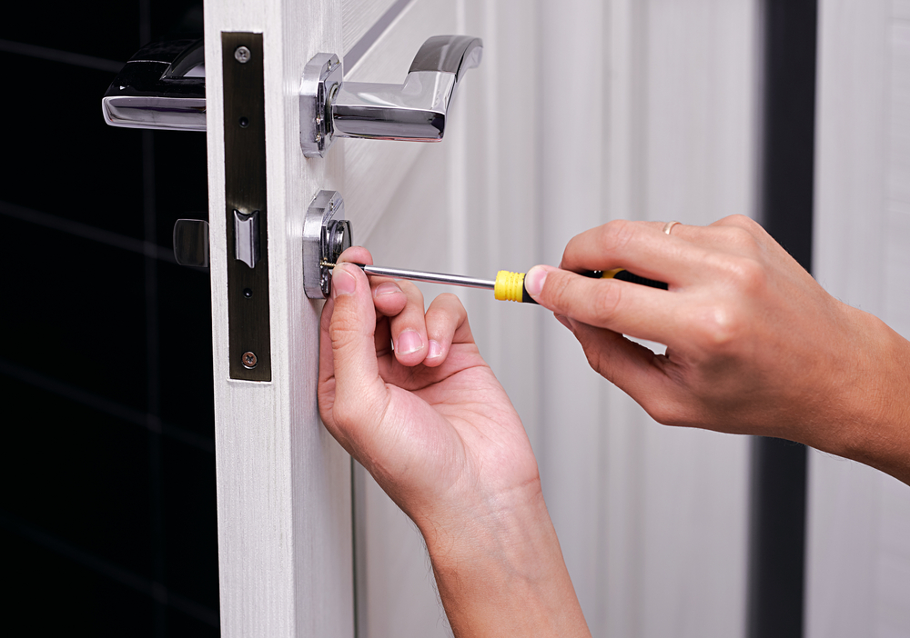 handyman working on door handle and lock